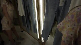A couple is trying on clothes and gets horny in the fitting room