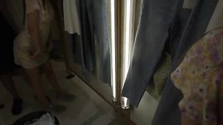 A couple is trying on clothes and gets horny in the fitting room