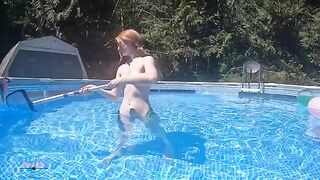Redhead in red bikini underwater in the pool