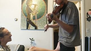 A couple gets passionate while the girl tries to practice violin, showcasing real intimacy