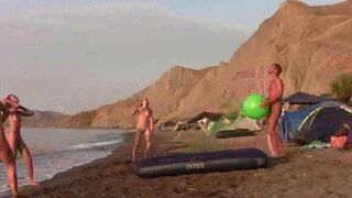 A sexy game of badminton without clothes on the nudist beach