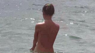 Nudists enjoy each other company on the bare beach