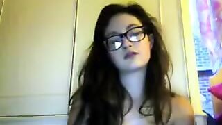 A cute student with glasses removes her clothes during a video chat