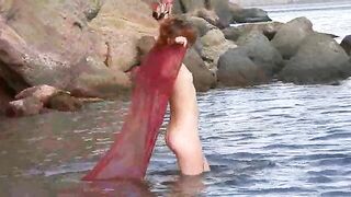 A girl with small boobs gets them wet while walking naked outdoors