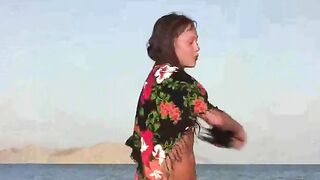 A member shows a girl the secrets of nudity on the beach