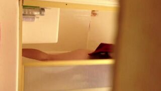 A girl washes in the shower, unaware of the camera