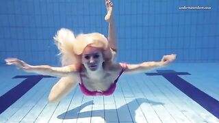 A hot and sexy chick is swimming naked in the pool