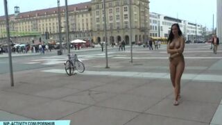 A hot chick is walking naked on the city streets, very daring