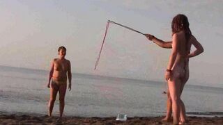 A naked girl is having fun on the beach, showcasing her body