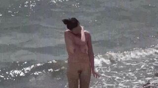 A couple of nudists enjoy a nice day on the beach without clothes