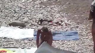 A couple of nudists enjoy a nice day on the beach without clothes