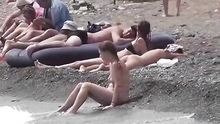 A couple of nudists enjoy a nice day on the beach without clothes