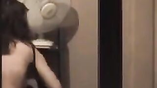 A hot brunette poses naked in front of the mirror, admiring herself with a big dick