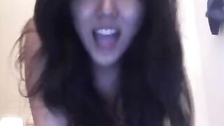 An Asian girl masturbates on the bed, showcasing her solo skills