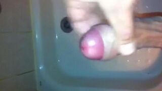 The kid masturbates his dick in the shower stream