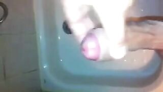 The kid masturbates his dick in the shower stream