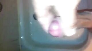 The kid masturbates his dick in the shower stream
