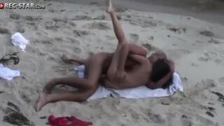 A girl is fucking on the beach with someone using a camera