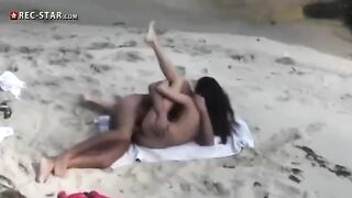 A girl is fucking on the beach with someone using a camera