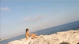 The girl sunbathes naked on the beach