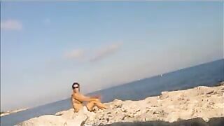The girl sunbathes naked on the beach