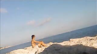The girl sunbathes naked on the beach