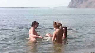 A group of naked beauties have a lot of fun on the beach