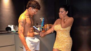 The host greeted the new maid with a package in the kitchen