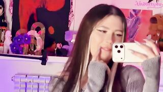 A girl in stockings caresses herself with a dildo in front of the mirror