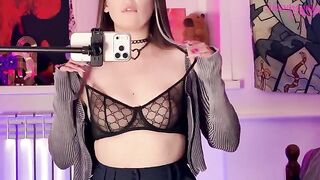 A girl in stockings caresses herself with a dildo in front of the mirror